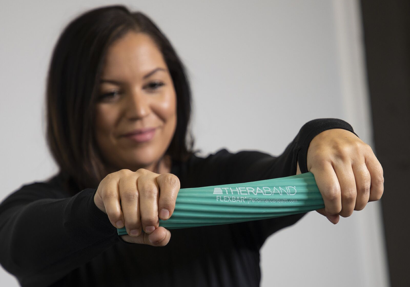 woman using THERABAND flexbar